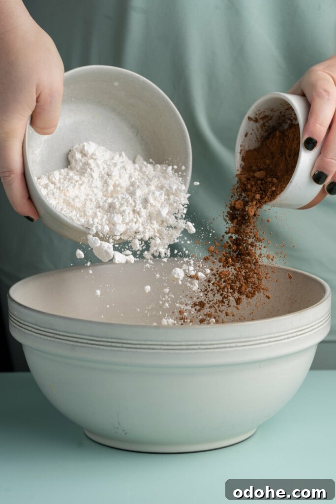 Adding flour and cocoa powder to cookie dough.