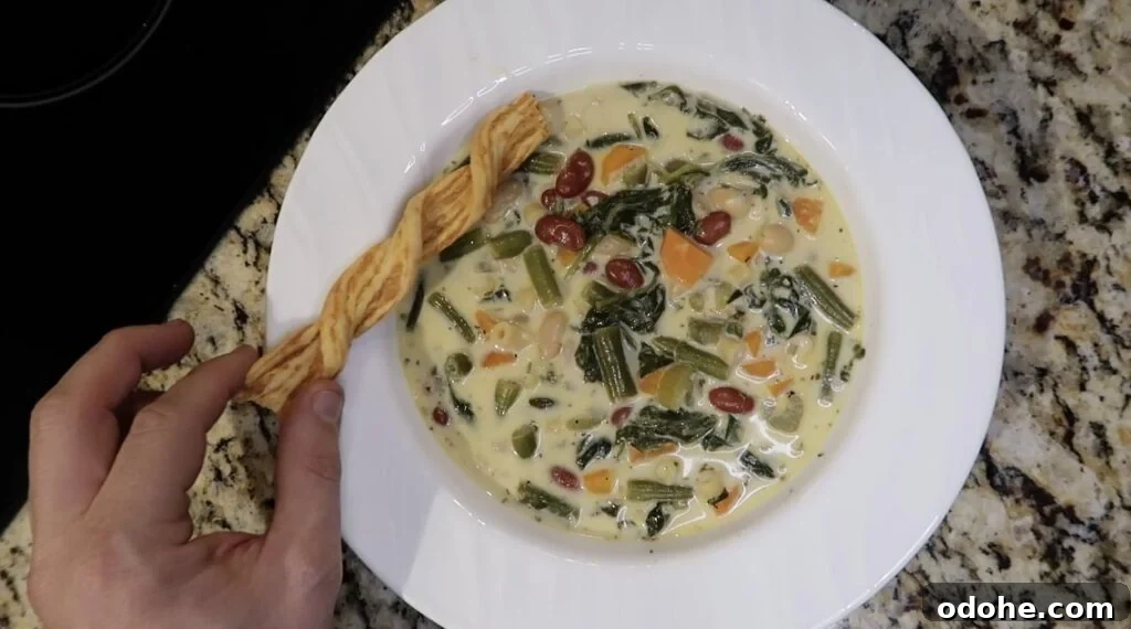 Soup in bowl with cheese crisp next to it