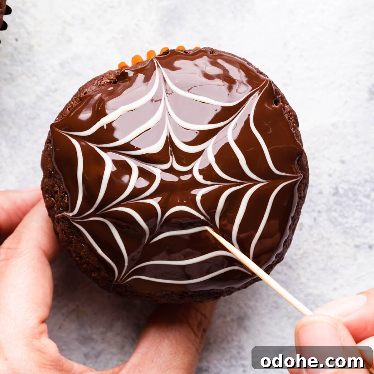 Chocolate Fudge Spiderweb Muffins Recipe — Decadent Halloween Treat 11 a chocolate web decoration in the making on top of the chocolate muffin.