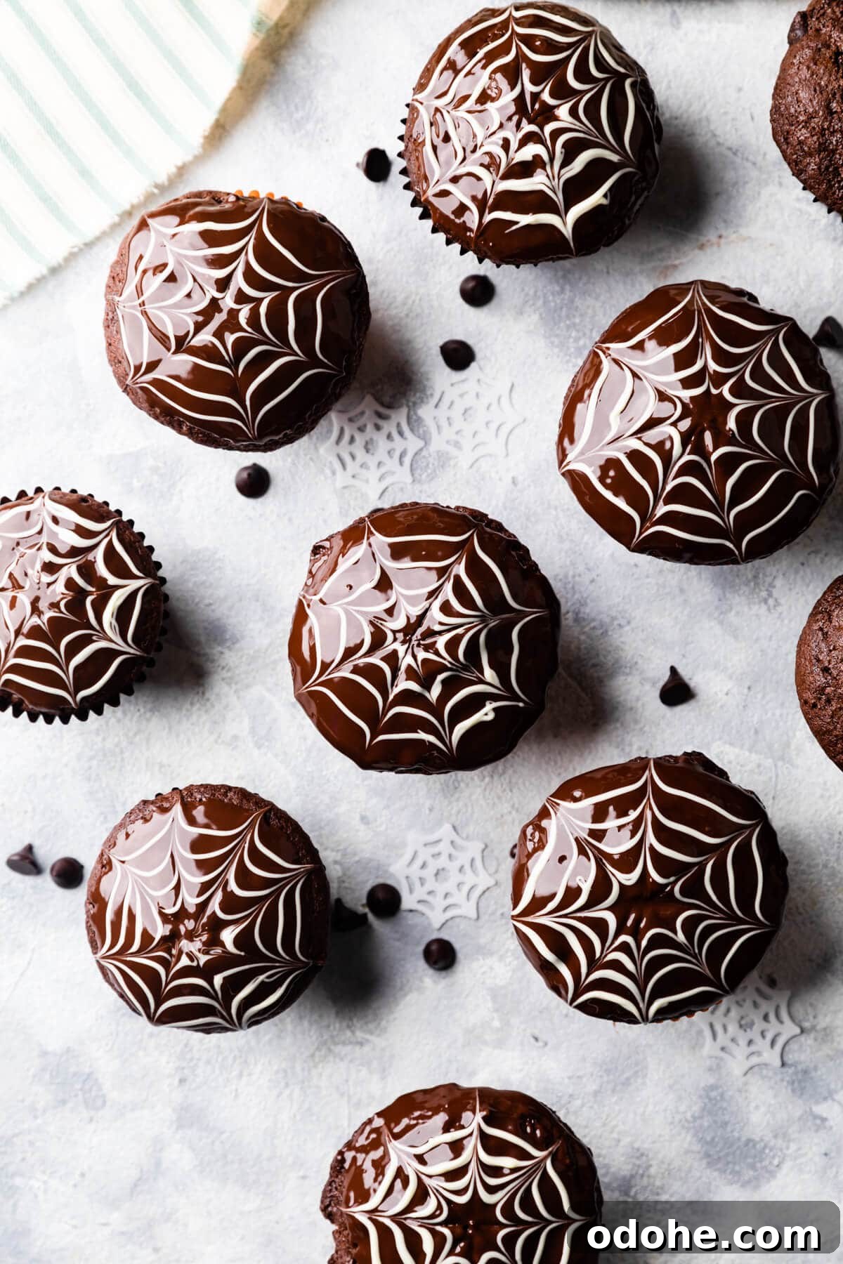 Chocolate Fudge Spiderweb Muffins Recipe — Decadent Halloween Treat 12 batch of chocolate fudge muffins with spiderweb decorations on top.