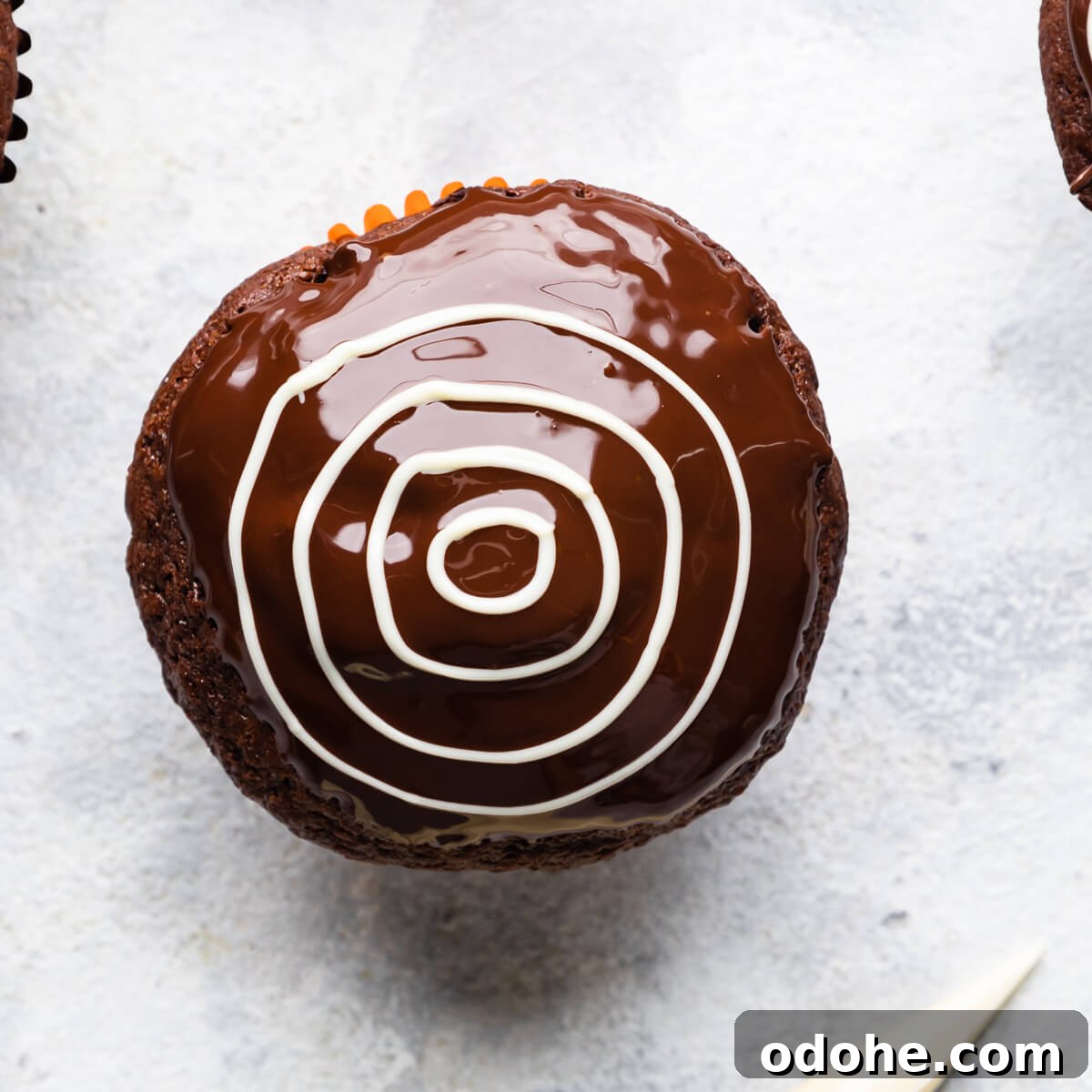 Chocolate Fudge Spiderweb Muffins Recipe — Decadent Halloween Treat 9 chocolate muffin topped with melted chocolate.