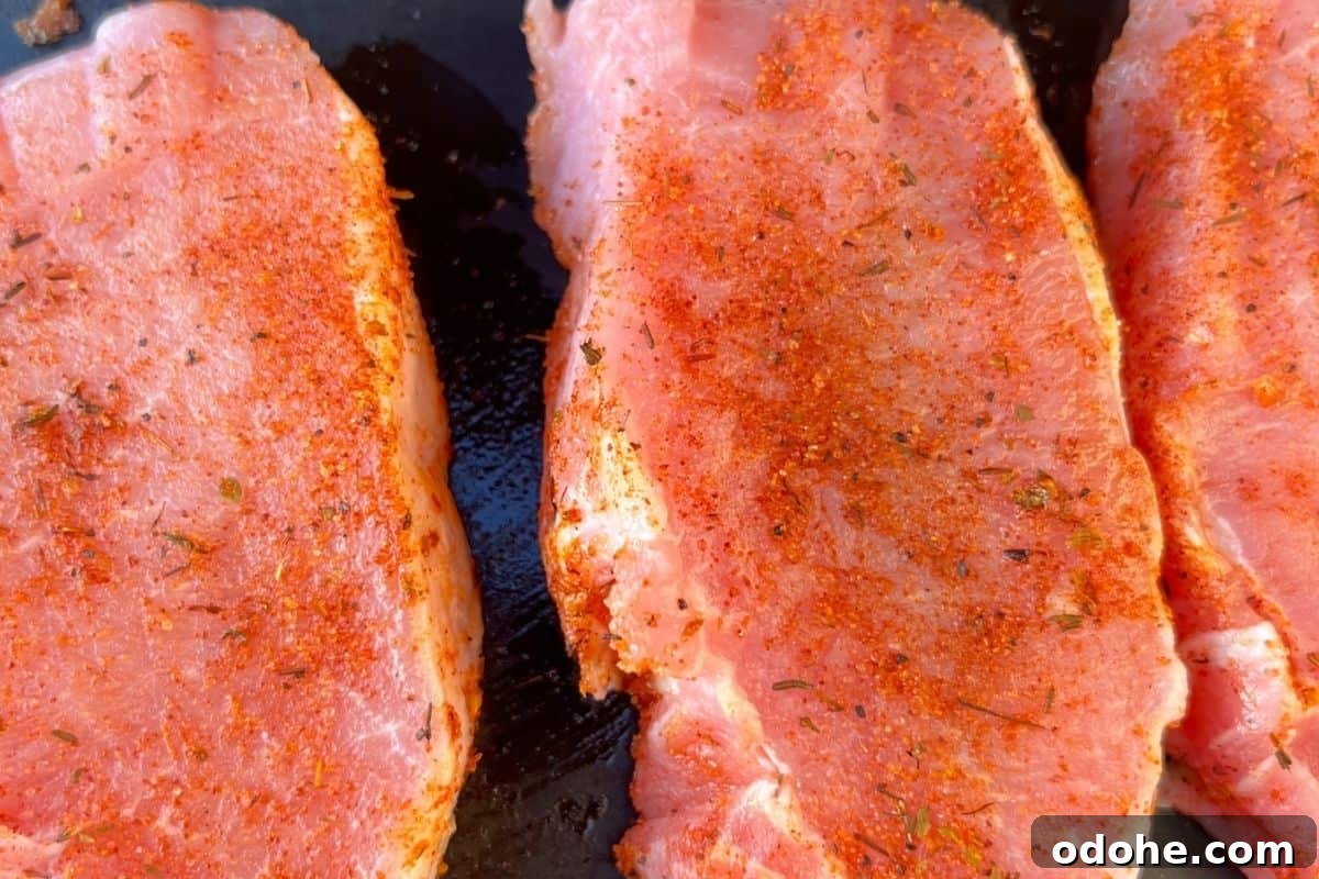 Seasoned coated pork chops on blackstone griddle. 