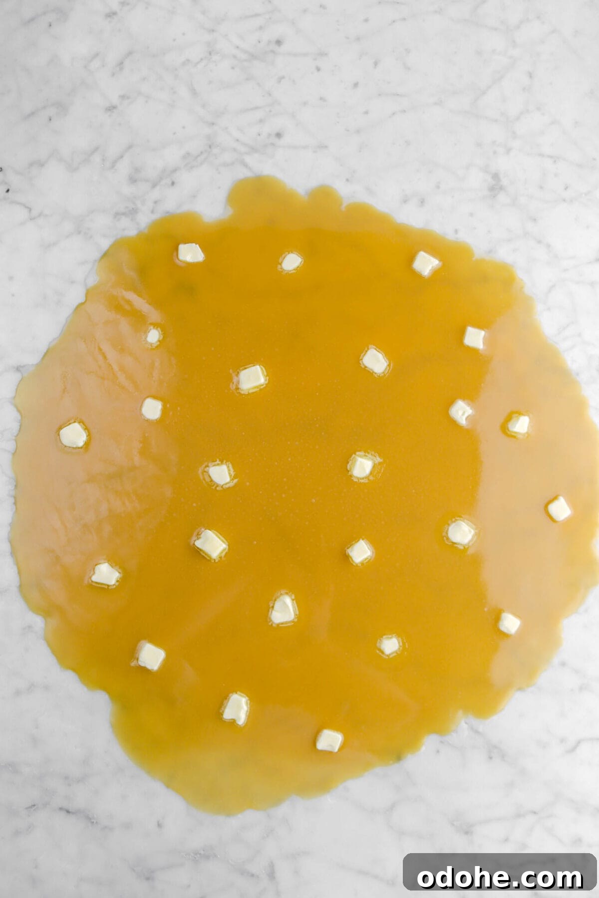 butter dolloped onto caramel on marble surface.