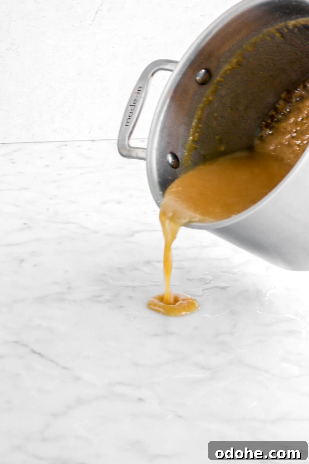 caramel being poured onto wet marble counter.