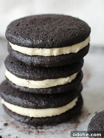 Three homemade oreo cookies stacked on a grey countertop