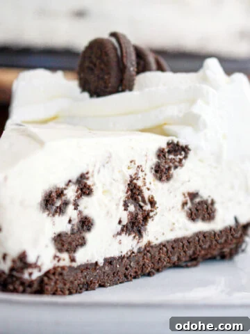 Close up of Oreo no bake cheesecake slice on a gray plate.