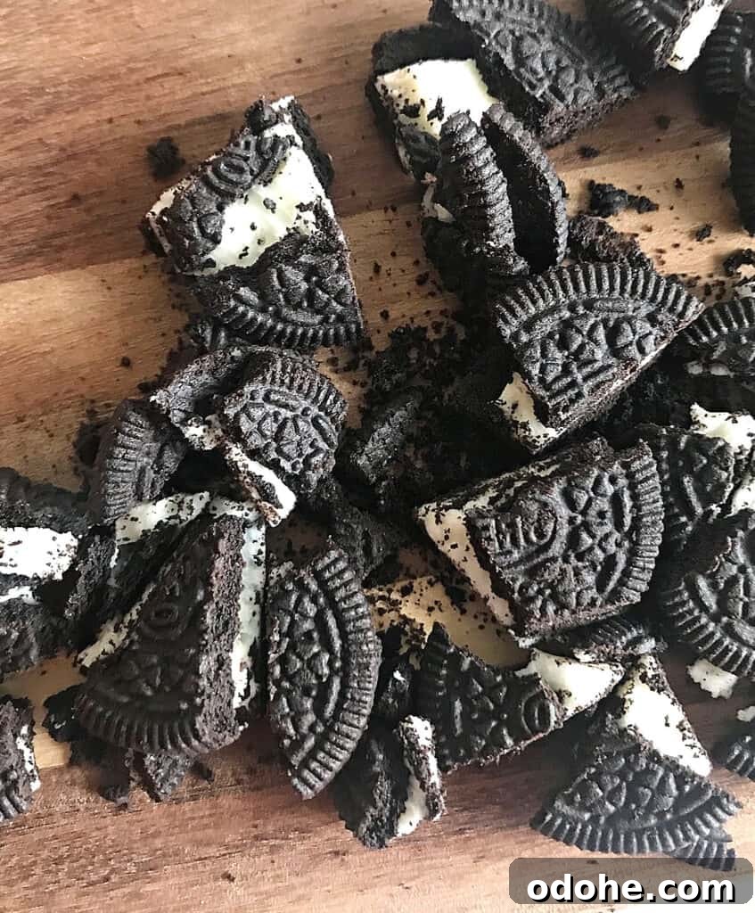 Chopped Oreo cookies on a wooden board.