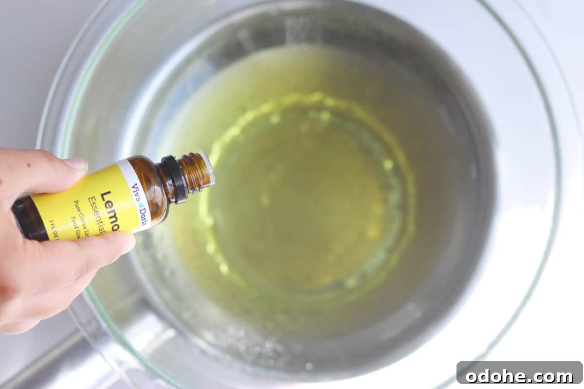 DIY Beeswax Leather Conditioner & Polish: Step-by-Step Guide 4 lemon essential oil being added to an oil mixture in a pot