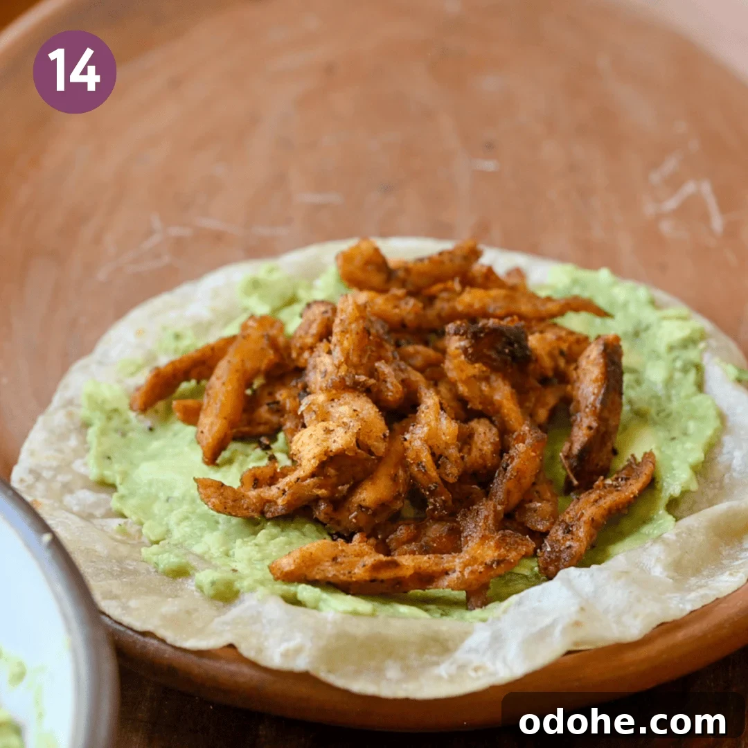 tortilla smeared with guacamole and topped with the soy curls on a plate.