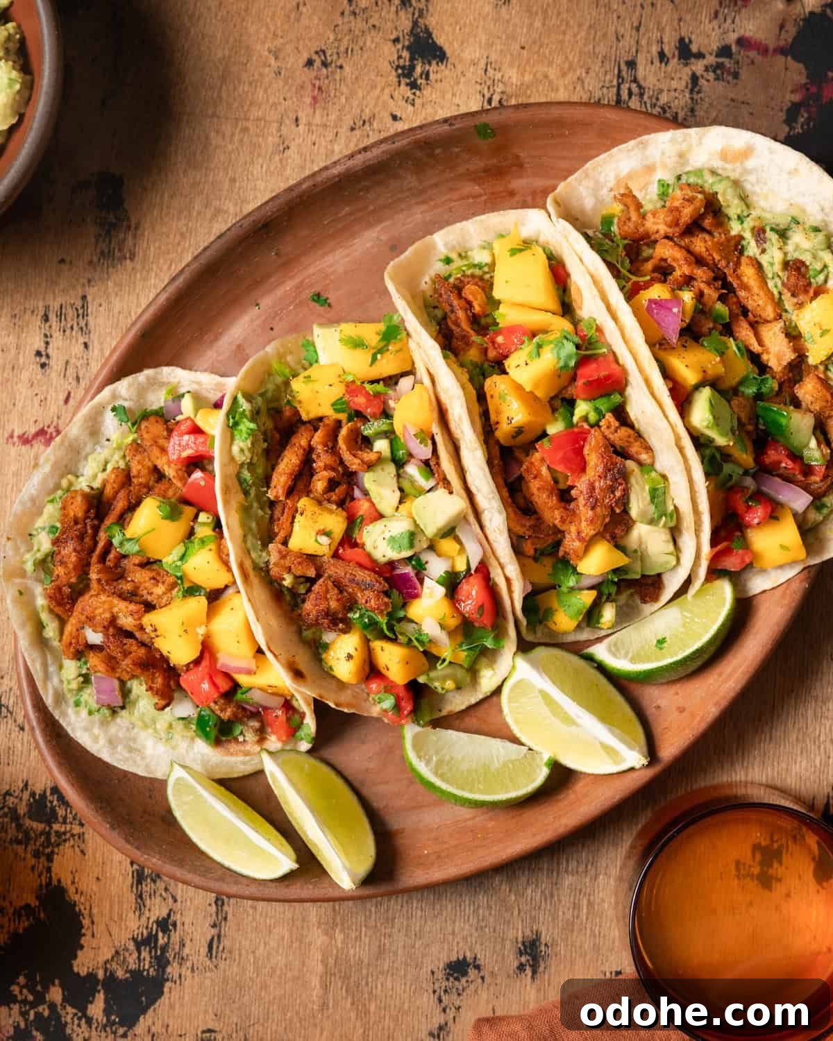 Overhead view of four vegan tacos with soy curls on a platter.