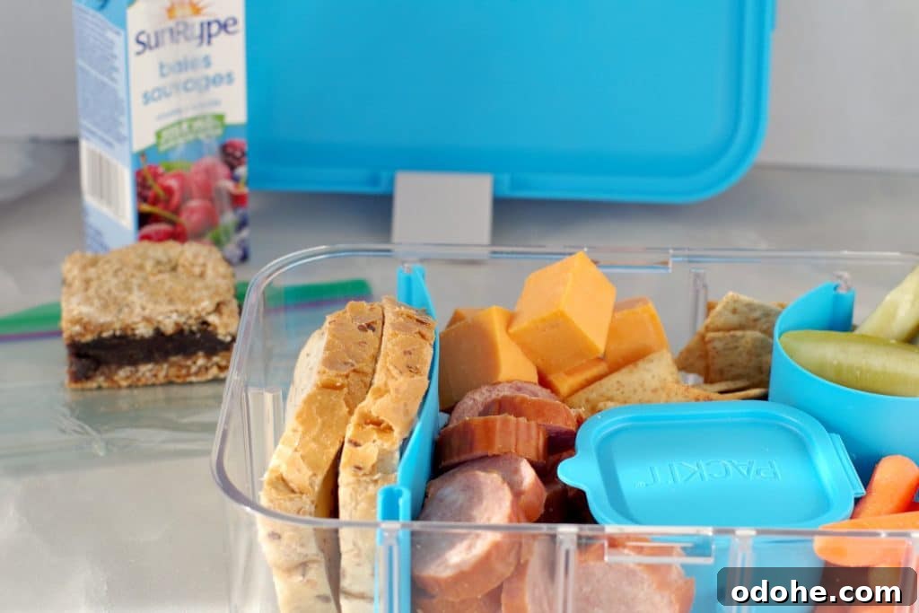 Ukrainian Bento Box Lunch: Compact Recipes for Packed Meals 2 Filled Ukrainian Bento box with juice box, date square and bento box lid in background
