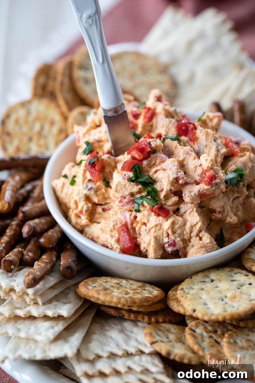 Smoky Roasted Red Pepper Dip Recipe 7 easy roasted red pepper dip in a bowl with pretzels and crackers.