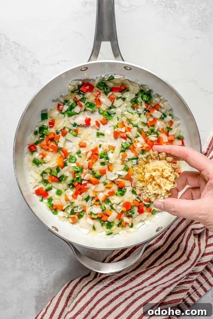 Creamy Shrimp Enchiladas Recipe 7 adding minced garlic to the sautéed veggies