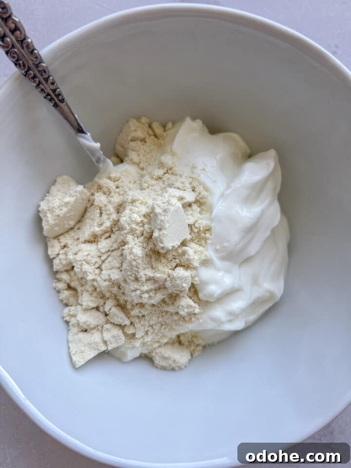 Greek yogurt and protein powder in a bowl, unstirred.
