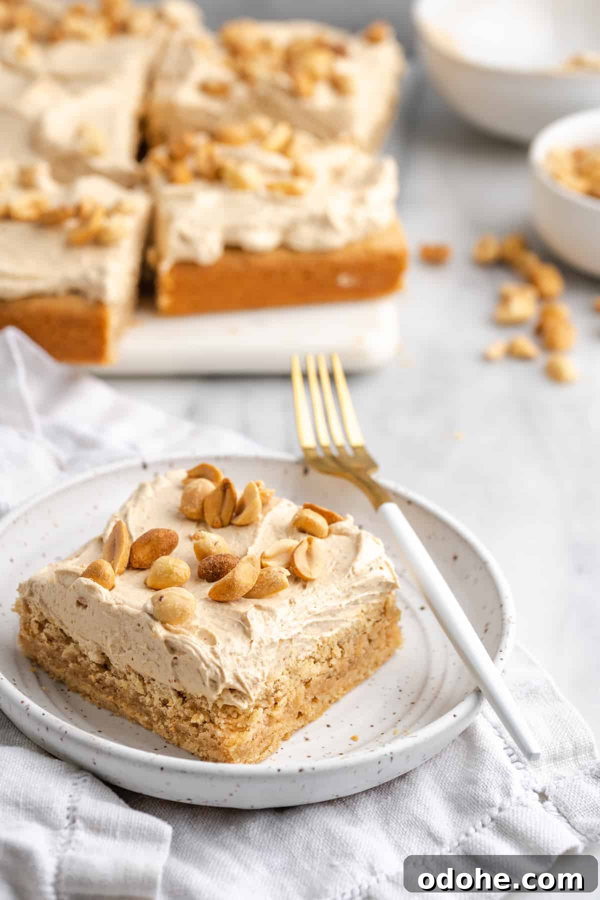 This delicious vegan peanut butter cake recipe is quick and easy to make, bursting with flavor, and the perfect treat with coffee or ice cream A piece of peanut butter cake on a plate with the rest of the cake in the back