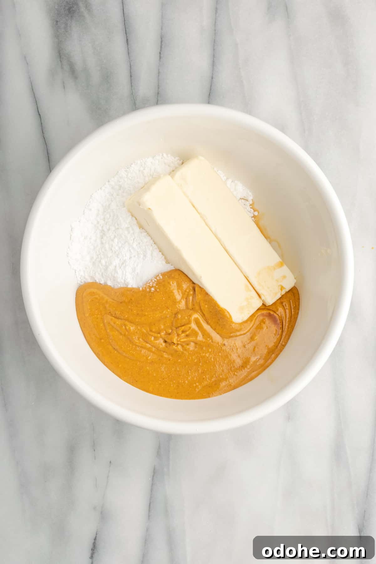 This delicious vegan peanut butter cake recipe is quick and easy to make, bursting with flavor, and the perfect treat with coffee or ice cream A bowl of peanut butter, butter, and sugar