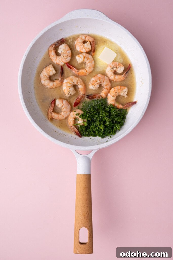 Creamy One-Pan Shrimp Scampi Recipe for Quick Weeknight Dinners 11 Adding butter and fresh parsley to scampi.