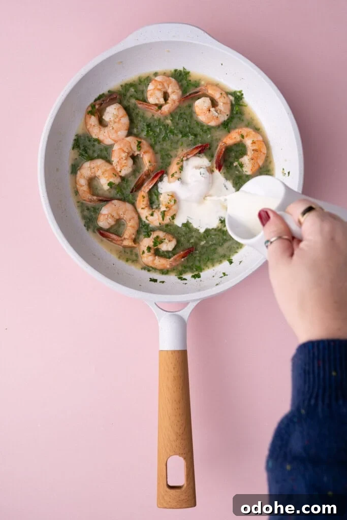 Creamy One-Pan Shrimp Scampi Recipe for Quick Weeknight Dinners 12 Adding heavy cream to shrimp scampi to make it nice and creamy.