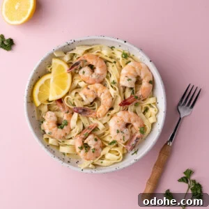 Creamy One-Pan Shrimp Scampi Recipe for Quick Weeknight Dinners 15 Creamy shrimp scampi served over pasta with lemon wedges.