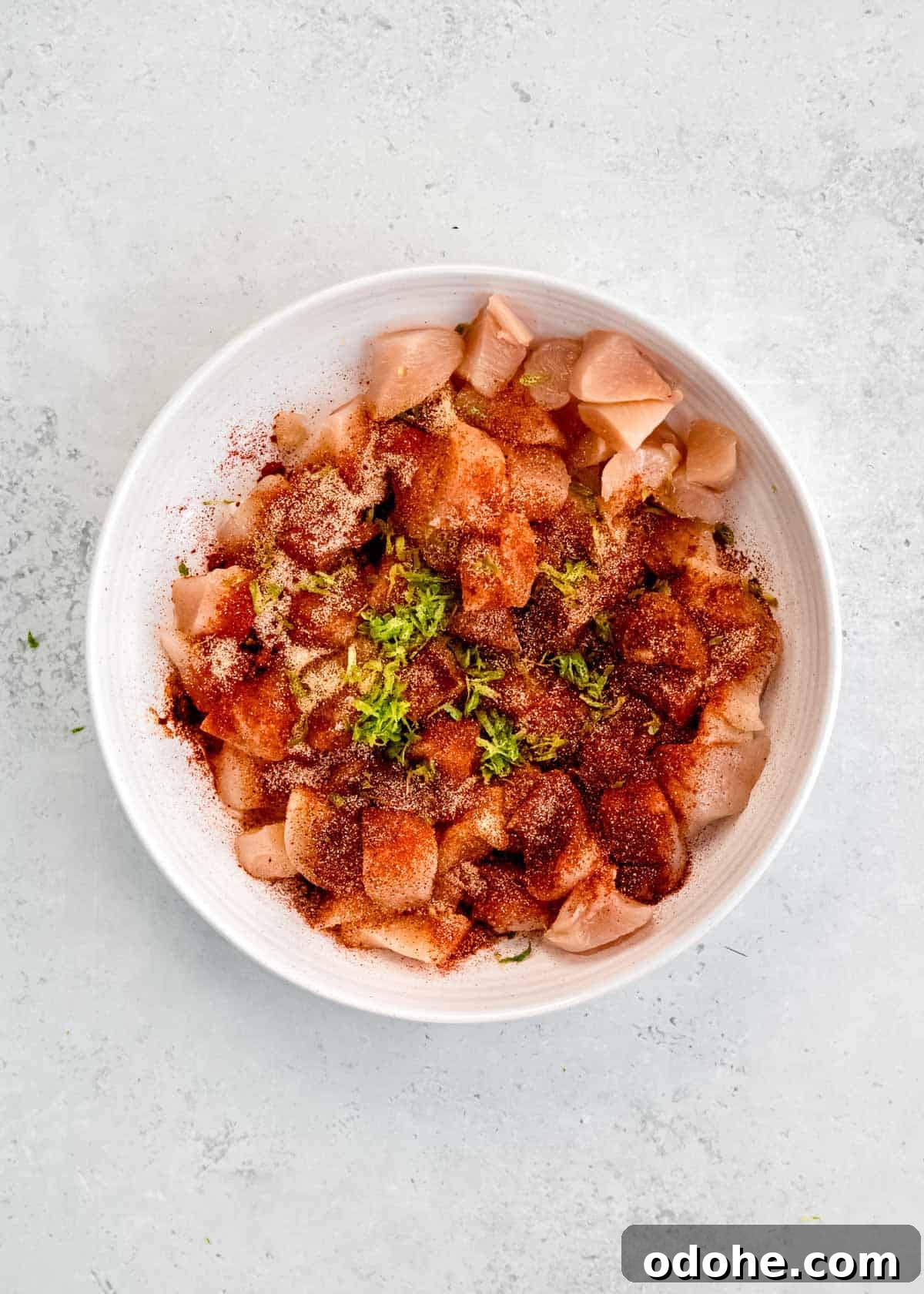 Cilantro Lime Chicken Bites for Air Fryer: Quick & Flavorful 4 spices being added to air fryer chicken bites in white mixing bowl