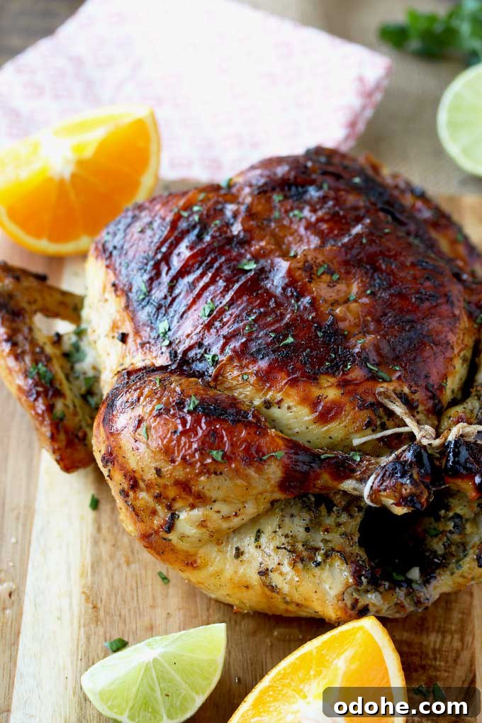 Whole Roasted Cuban Mojo Chicken on a wooden board.
