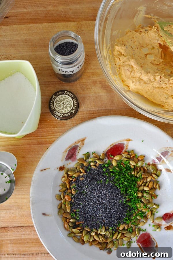 This manchego chipotle cheese ball is perfect for parties; coated with pumpkin and poppy seeds, and chives its a real crowd pleaser. Gluten-free! Manchego Chipotle Onion Cheese Ball