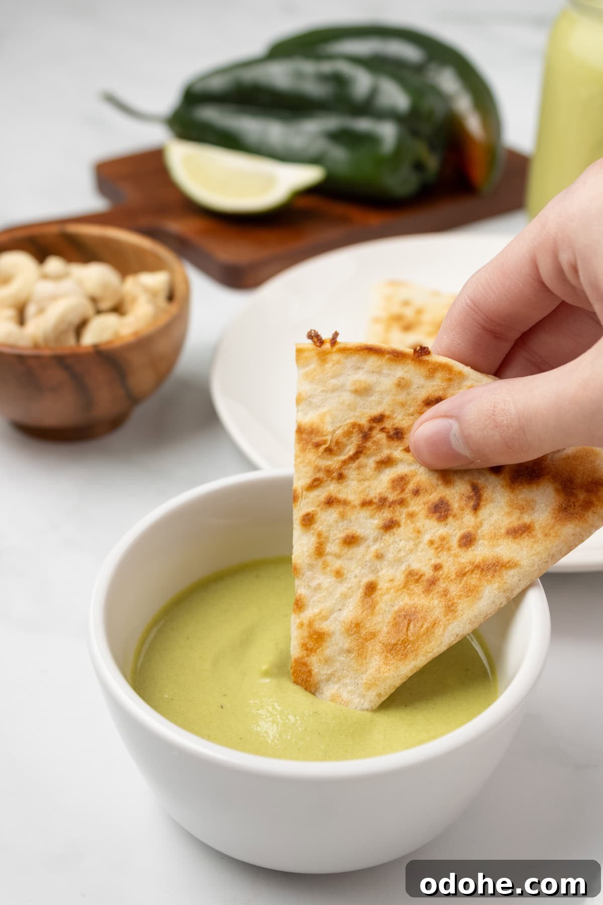 An image of dipping a flatbread to the poblano sauce.