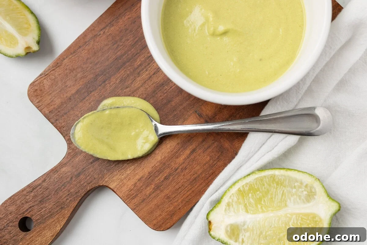 An overhead image of a spoonful of poblano sauce with a bowl of sauce on the side.
