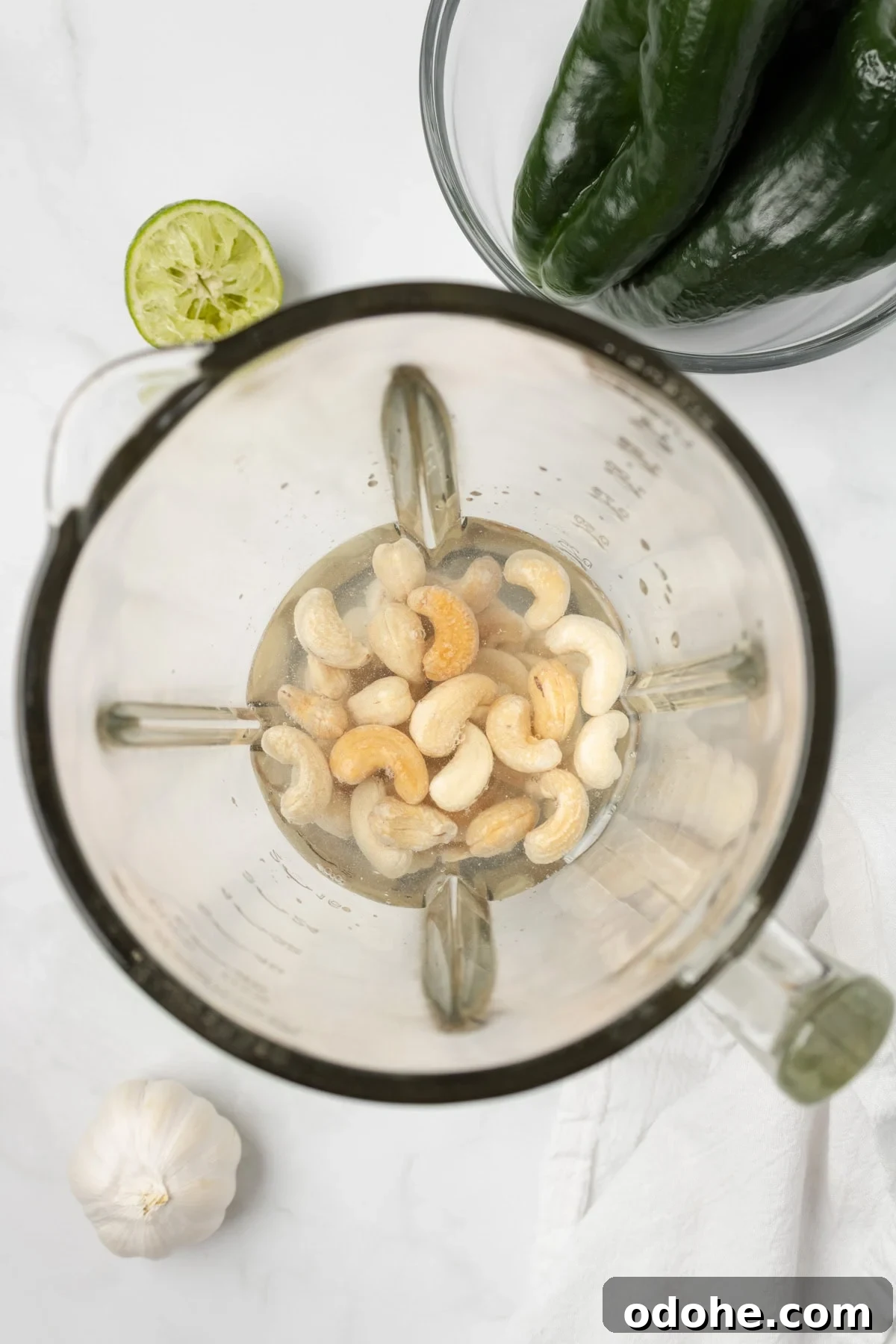 An overhead image of soaking cashews with water in a blender.