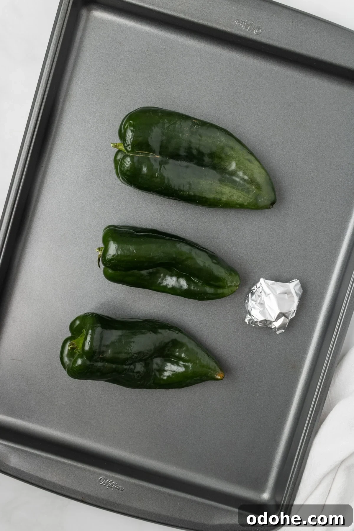 An overhead image of roasting the poblano peppers and garlic in the oven.
