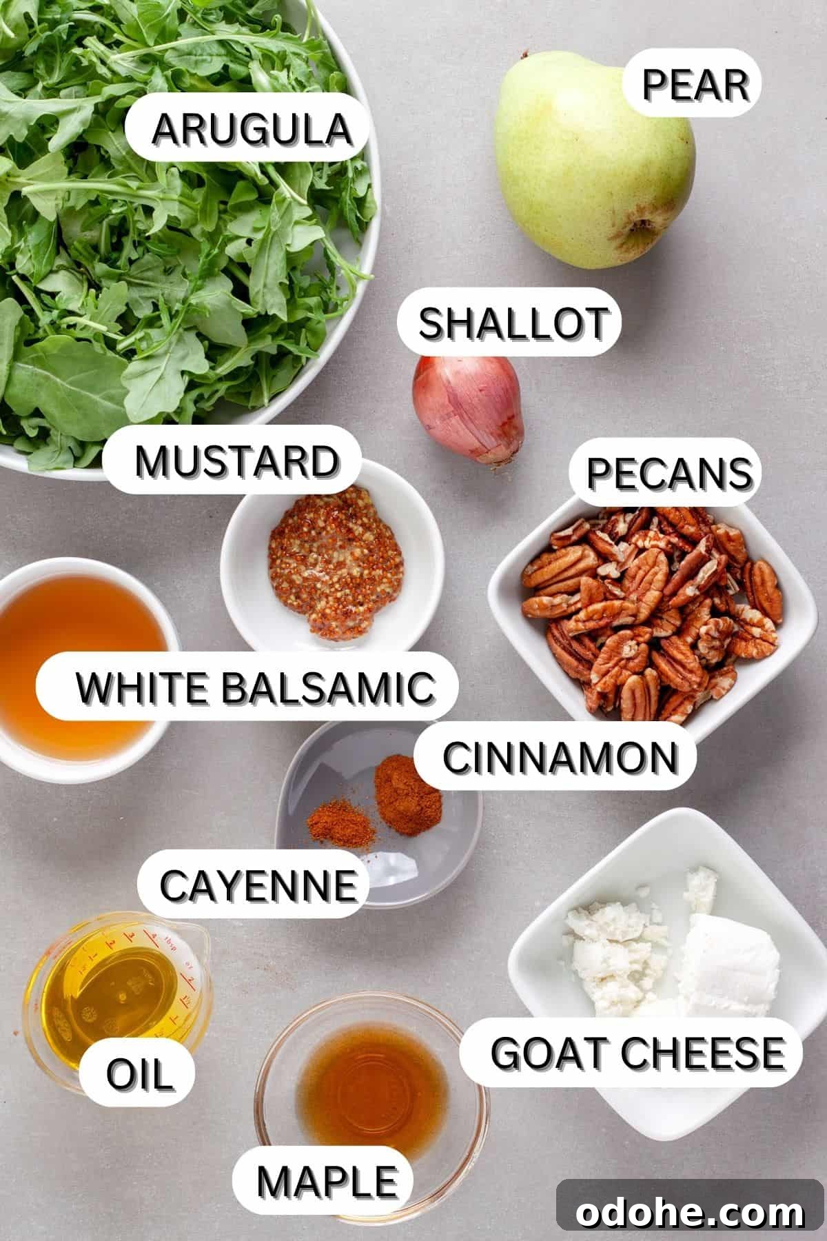 Ingredients for an arugula and pear salad on a gray table.