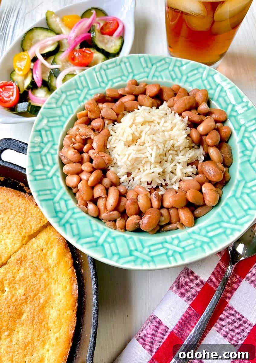 Southern Pinto Beans and Rice Recipe — Classic Soulful Side Dish 2 Pinto beans and rice in turquoise bowl on table.