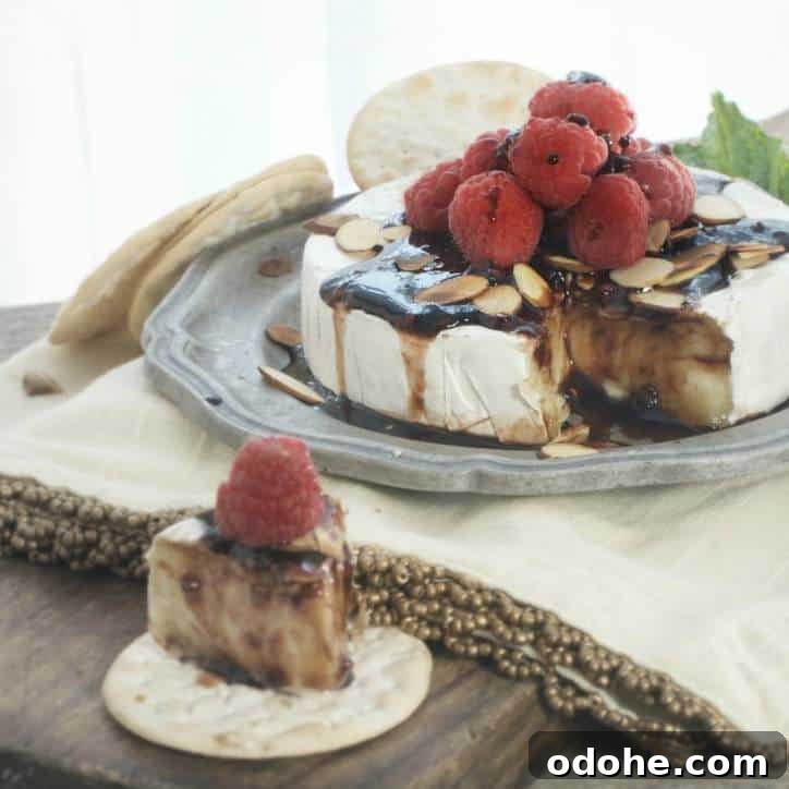 Toasted Almond and Raspberry Baked Brie Recipe for Entertaining 3 A photo of the Toasted Almond Raspberry Baked Brie with the slice and the wheel of cheese