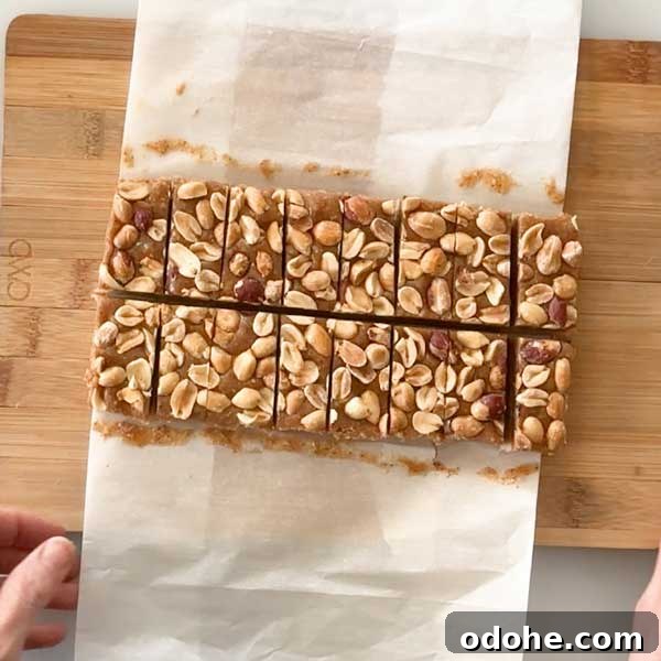Gluten-Free Snickers Copycat Recipe: Homemade Chocolate Caramel Nougat 12 Frozen and sliced snickers bars on a parchment paper.