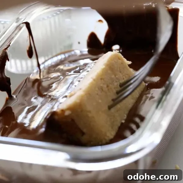 Gluten-Free Snickers Copycat Recipe: Homemade Chocolate Caramel Nougat 16 Rolling the snickers bar in the melted chocolate with a fork.