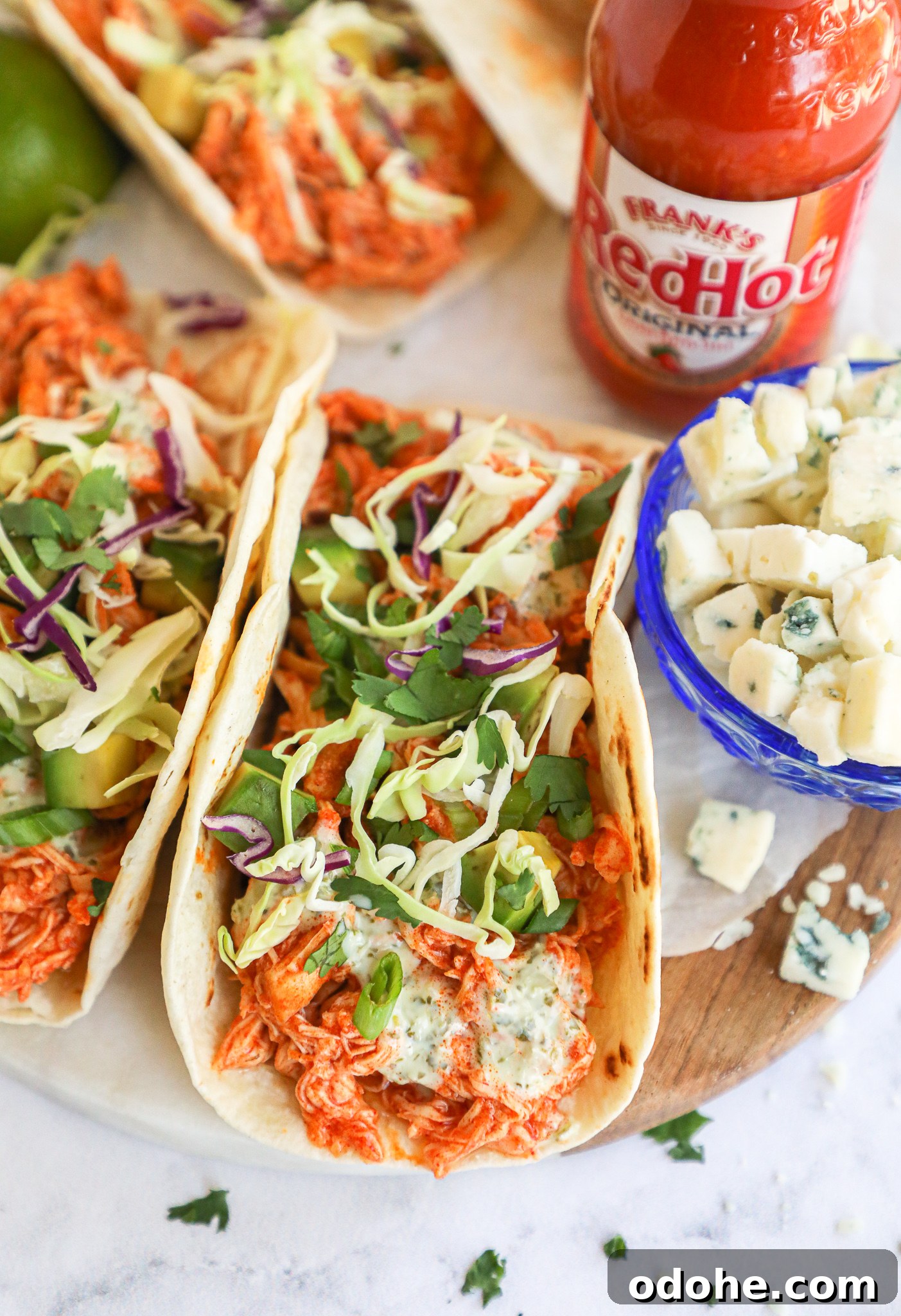Baked Buffalo Chicken Tacos with Cilantro-Lime Crema 4 Shredded seasoned chicken is tossed with a spicy hot sauce, then stuffed into flour tortillas and topped with a creamy cilantro lime sauce! You won't be able to get enough of these tasty tacos!