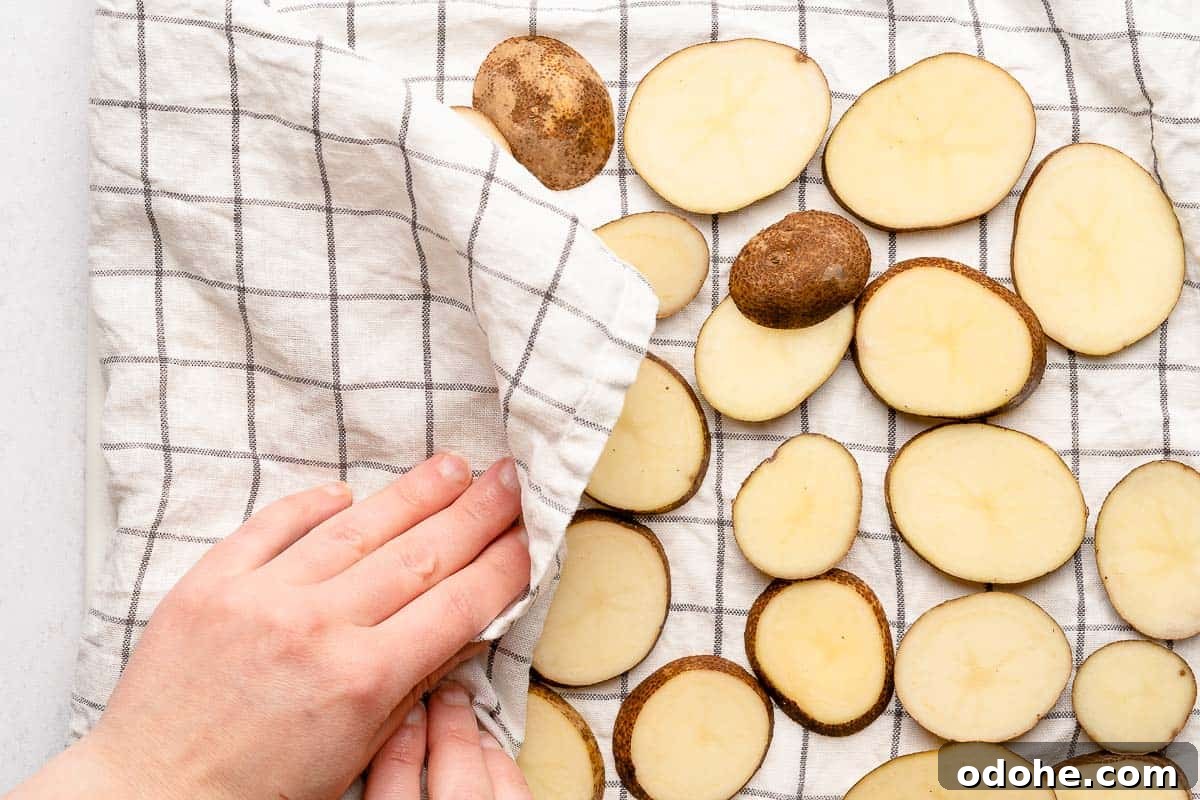 Crispy Cottage Fries Recipe: Homemade Seasoned Potato Wedges 6 hand blotting sliced potatoes with kitchen towel