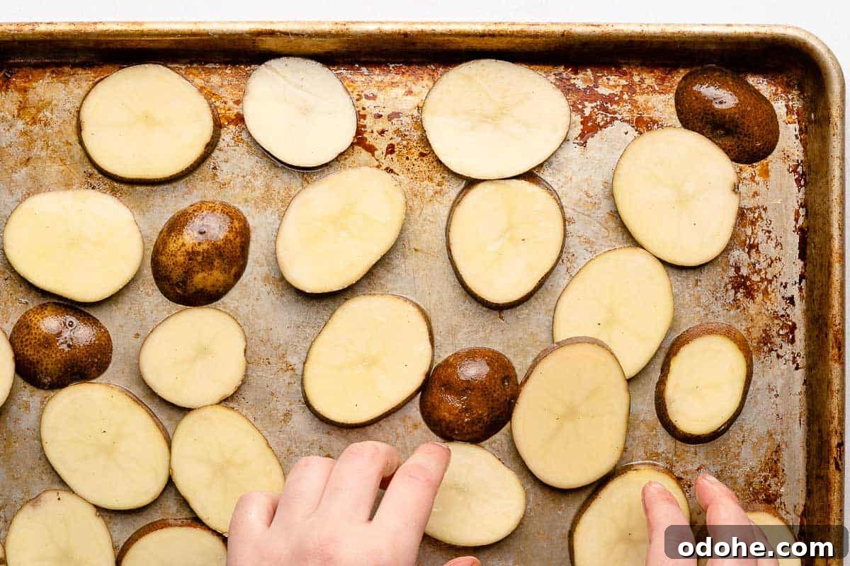 Crispy Cottage Fries Recipe: Homemade Seasoned Potato Wedges 8 hands spreading potato slices out on baking sheet