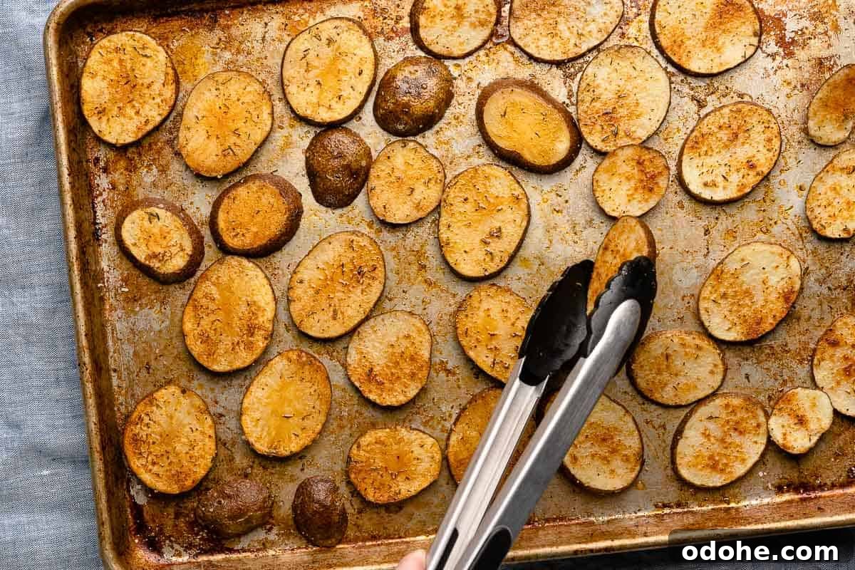 Crispy Cottage Fries Recipe: Homemade Seasoned Potato Wedges 10 tongs turning half cooked potatoes over on baking sheet