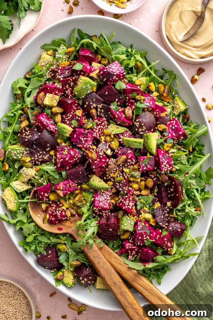 Roasted Beet Salad with Lemon Tahini Dressing and Pistachios 2 Overhead view of roasted beet salad served on a platter with a serving spoon