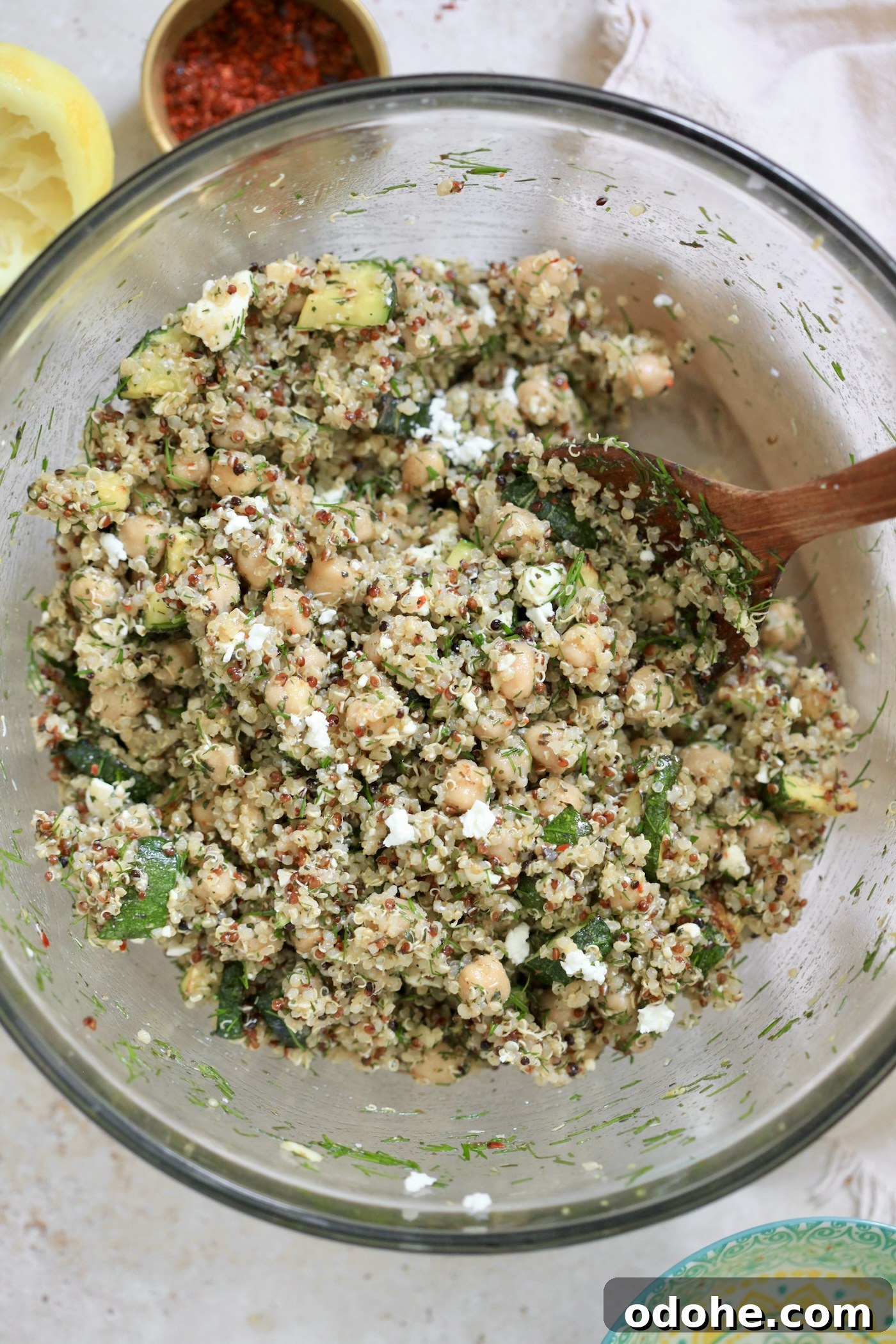 Zucchini, Quinoa & Chickpea Salad with Feta and Fresh Dill 9 quinoa zucchini salad in mixing bowl with lemon.