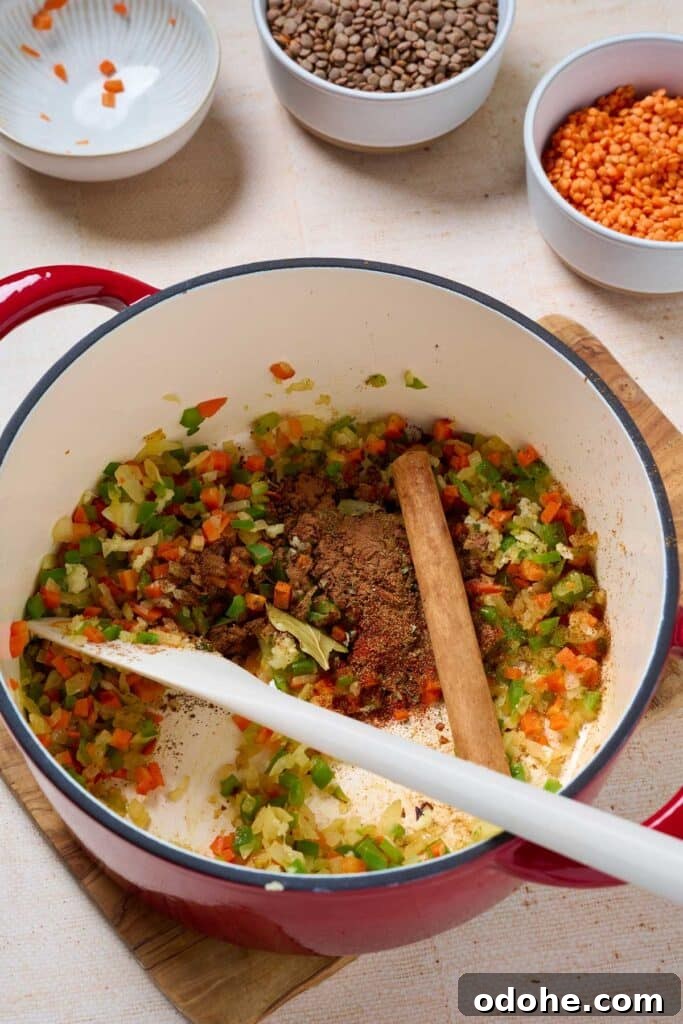Cincinnati-Style Lentil Chili Recipe for Rich, Hearty Flavor 6 Spices, bay leaf and cinnamon stick added to sautéed aromatics in a pot