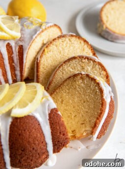 lemon bundt cake with slices leaning against each other on cake plate.
