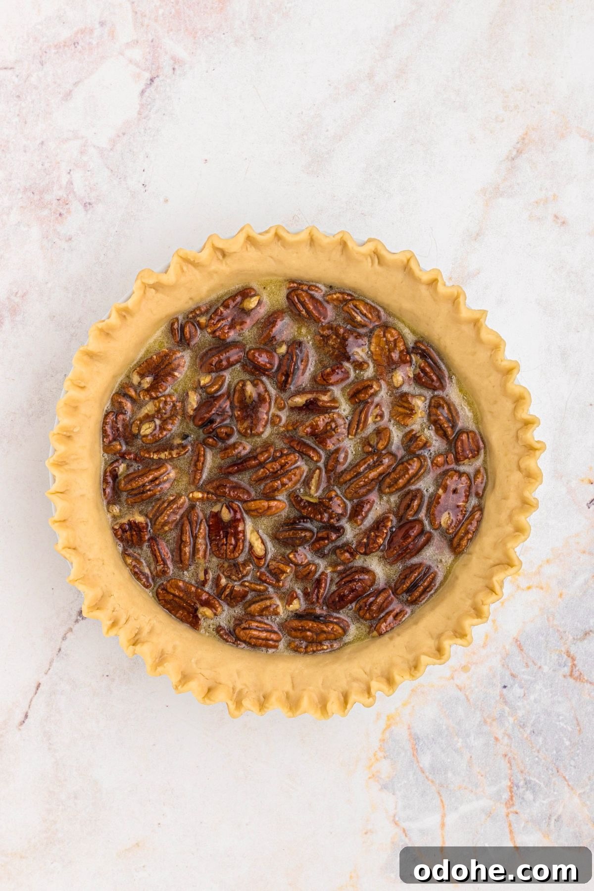 Pecans, eggs, and corn syrup, mixed together with sugar and other ingredients, then poured into an unbaked pie crust.