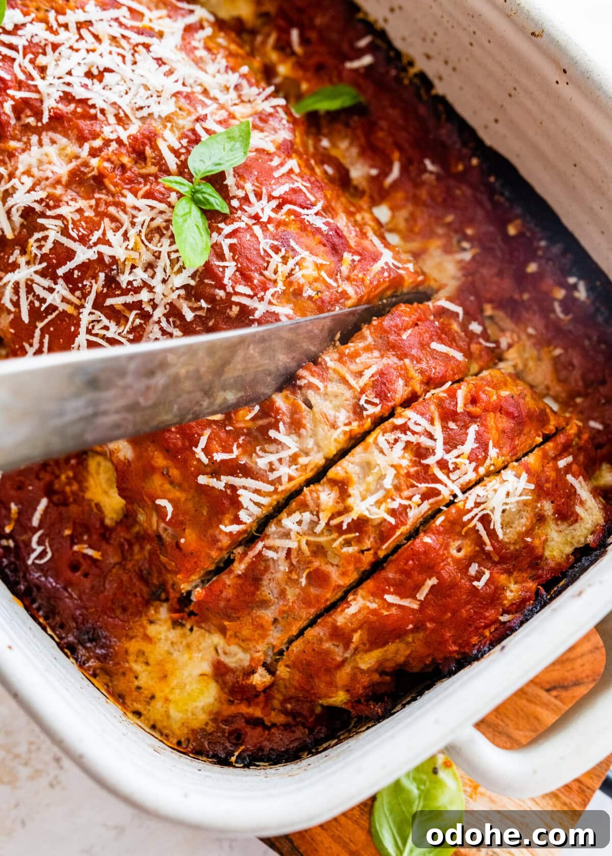 Cutting the meatloaf with a knife in the pan.