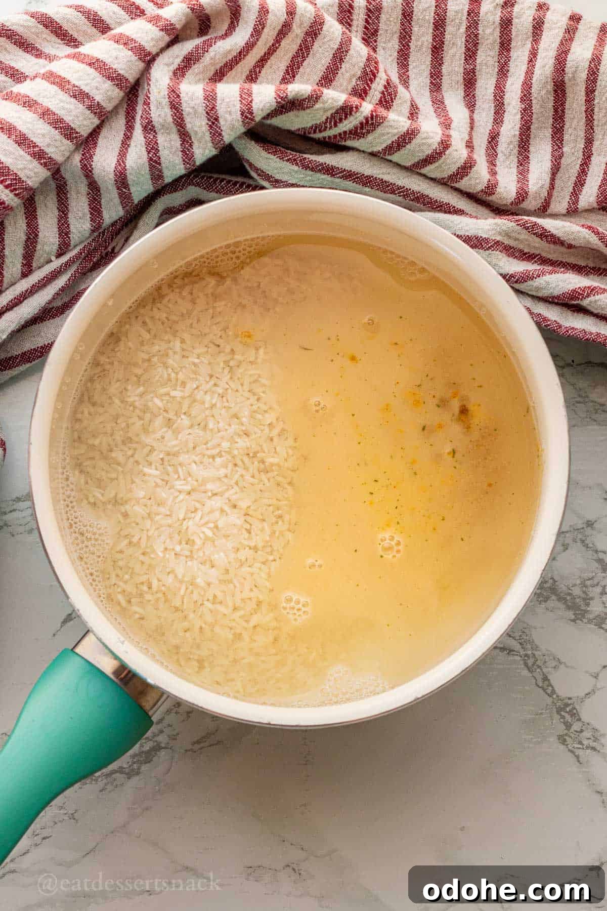 Cheesy Chicken, Rice & Veggie Casserole Recipe 4 Raw rice and chicken broth in metal pot.
