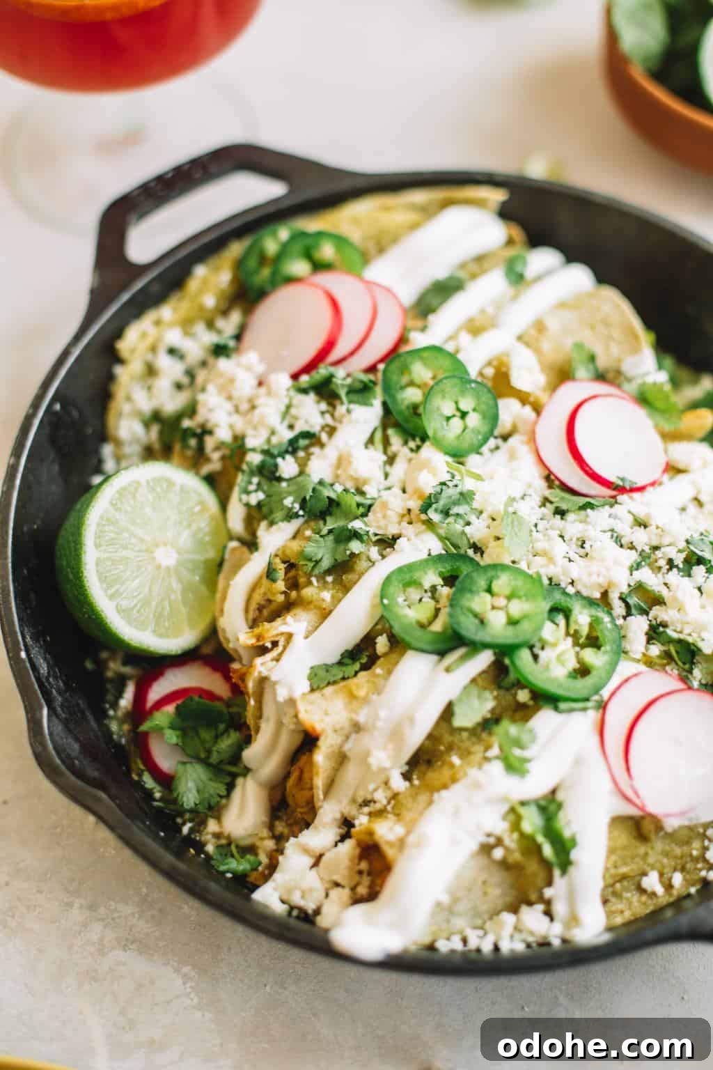 Easy Green Chicken Enchiladas Cast iron skillet filled with green chicken enchiladas
