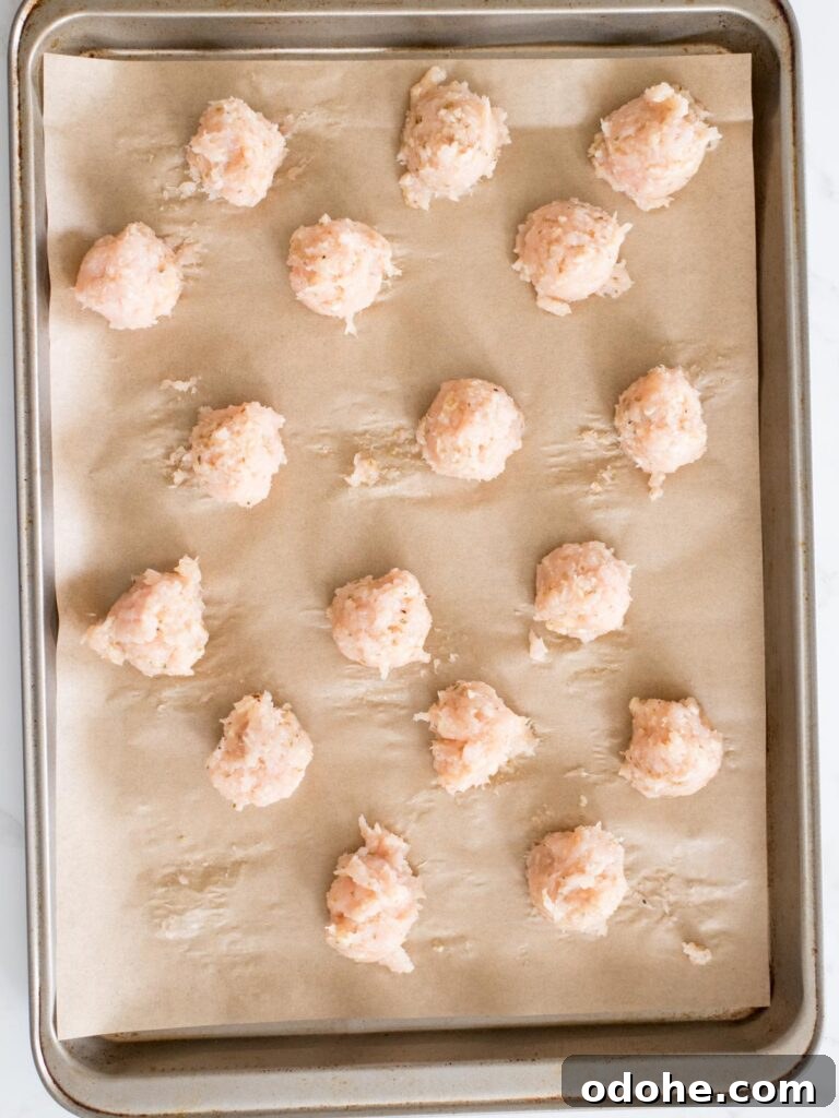 Sticky-Sauce Chicken Meatballs with Sweet Glaze 10 chicken meatballs on a parchment lined sheet pan