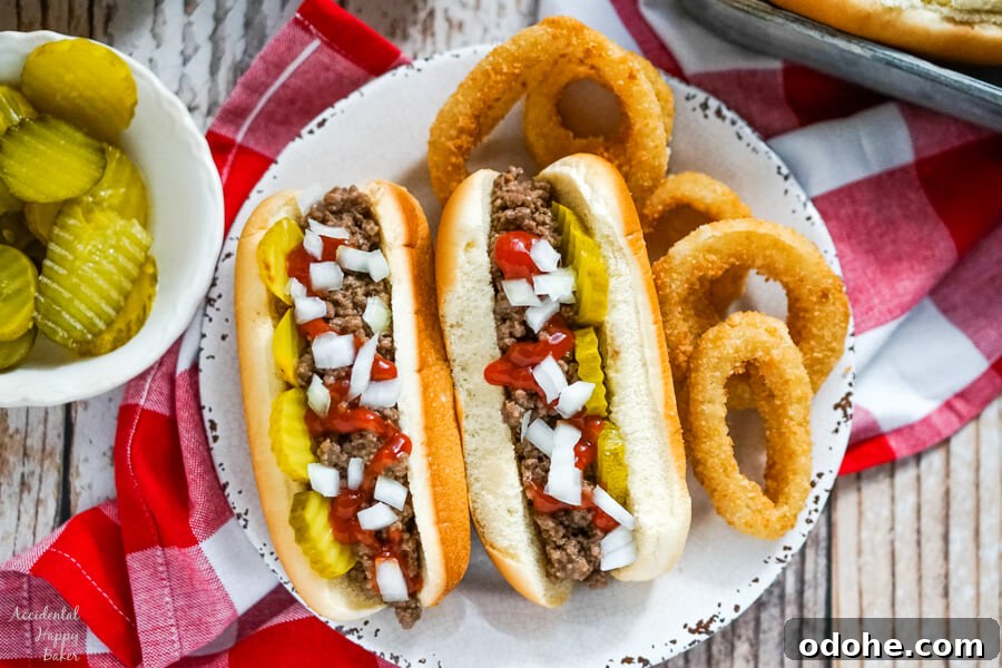 Juicy Midwestern Loose Meat Sandwich Recipe for Classic Burgers 3 Two Juicy Burgers topped with pickles, onions and ketchup on a plate with onion rings.