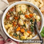 This is a square picture of a bowl or cauliflower lentil soup.
